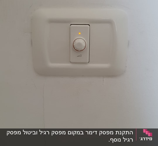 מתג דימר עם נורית חיווי על קיר לבן